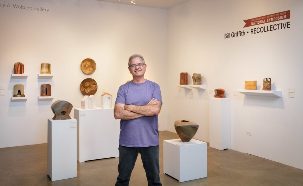 Bill Griffith stands with a display of his pots
