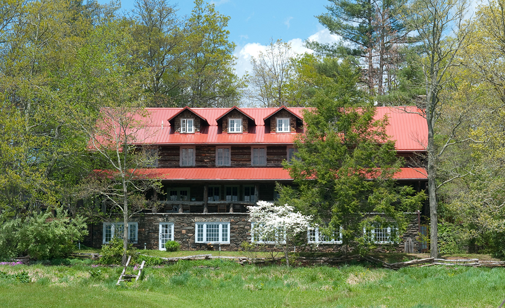 Front view of the Craft House with its iconic log porch and red roof