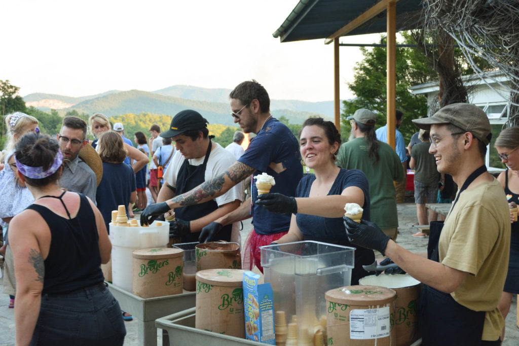 core fellows serve up ice cream from big cardboard tubs