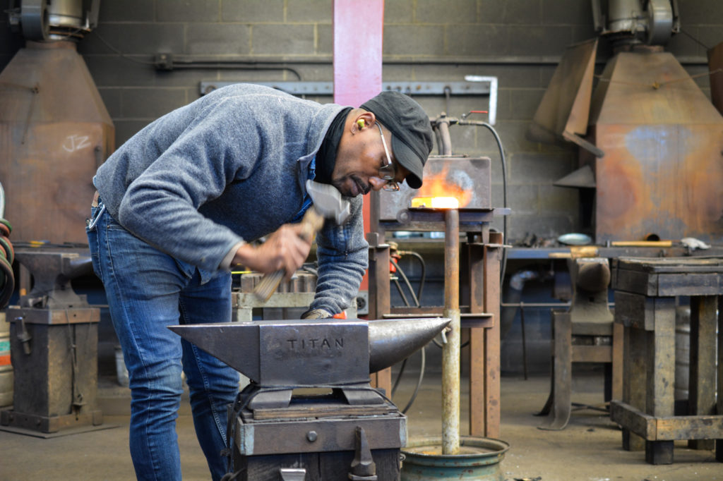 Metalsmith David Clemons working at the forge in the Penland iron studio