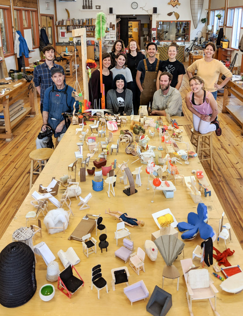 spring wood concentration students posing with a table full of mini chair models