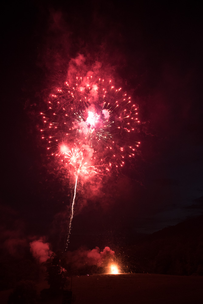 The knoll shining red with the help of some fireworks and a few thousand bottle rockets