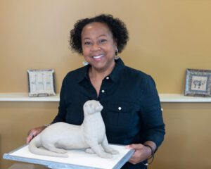 Portrait of Tina Curry with dog sculpture
