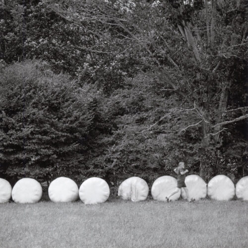 Robin Dreyer, Hay Bales (photographer shown for scale), gelatin silver print, 7 x 7 inches